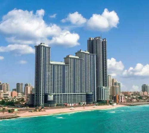 a city with tall buildings on the beach and the ocean at Best place to stay by the sea in Ajman