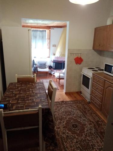 a kitchen and living room with a table and a stove at Olympos House in Litochoro
