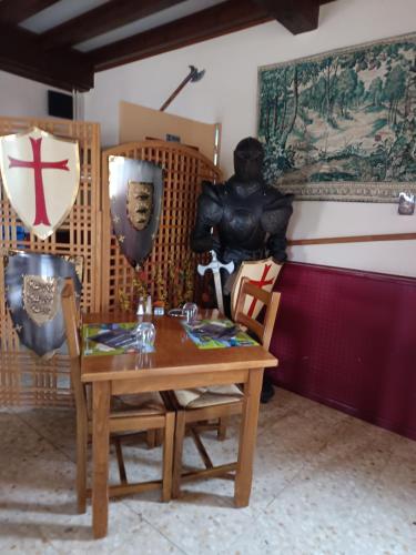 a dining room with a table and a statue at Auberge le Cévenol in La Cavalerie