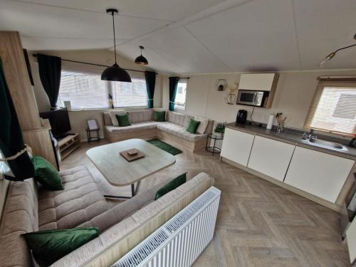 Kinmel BayにあるEllies caravan hireのソファとテーブルのあるリビングルーム