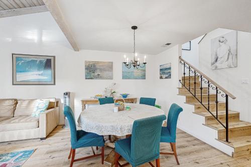 a dining room with a table and blue chairs at Sunny's Santa Barbara Beach House in Santa Barbara