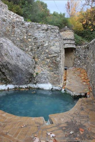 a small pool of water next to a stone wall at Beautiful House in Periana, Ideal for hikers in Periana