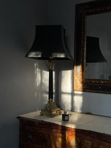 a lamp sitting on top of a table with a mirror at Podere la Botte in Lari