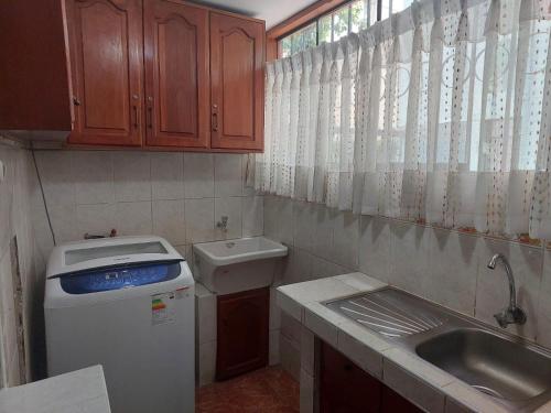 a small kitchen with a sink and a refrigerator at Mandalas Cusco in Cusco