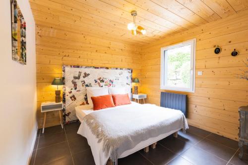a bedroom with a bed in a wooden room at chalets les biches in Gérardmer