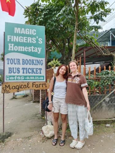 a man and a woman standing in front of a sign at Phong Nha Magic Fingers Homestay and Spa in Phong Nha