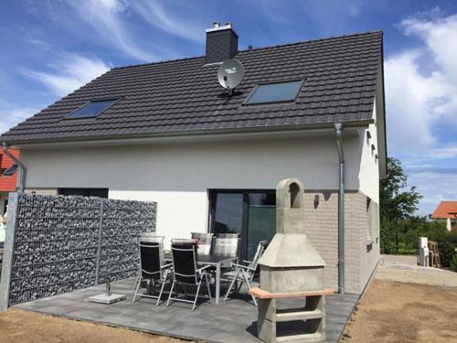 a house with a patio with chairs and a grill at "Segelboot" in Fuhlendorf