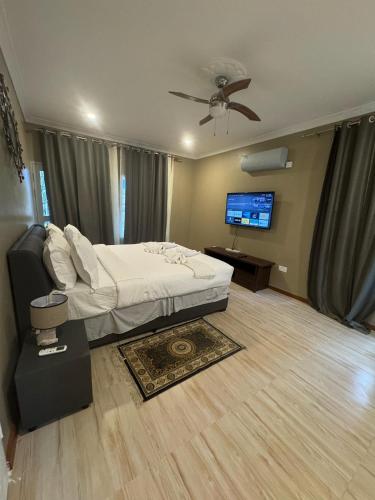 a bedroom with a bed and a flat screen tv at Meanwood Place Apartments in Lusaka