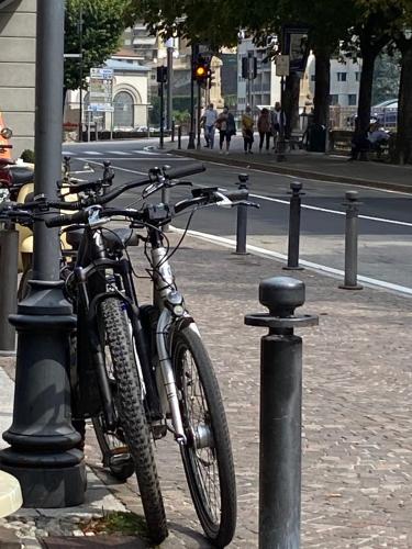 a bicycle is chained to a pole on a street at Il Dondolo di Villa Carlotta Mozzo in Mozzo