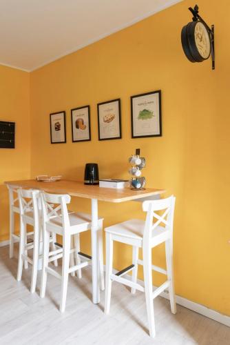 a dining room table with chairs and a clock on the wall at Il Dondolo di Villa Carlotta Mozzo in Mozzo