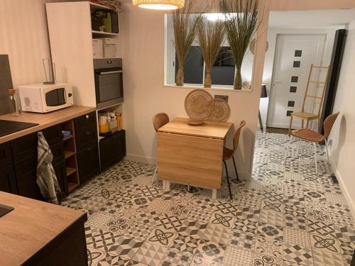 - une cuisine avec une table et un four micro-ondes dans l'établissement Centre-Ville Parking Gratuit Proche Aéroport, à Beauvais