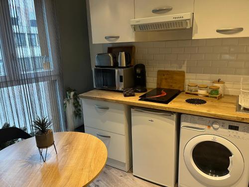 une cuisine avec une machine à laver et une table dans l'établissement Charment studio, aux Lilas