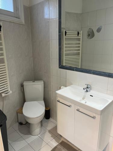 Un baño con un inodoro blanco y un lavabo. en Charment studio, en Les Lilas