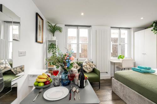 a living room with a table with fruit on it at Green Park Studios in London
