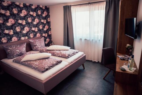 a bedroom with a bed with a floral wall at Gästezimmer im FamilienWeingut Räder in Hillesheim