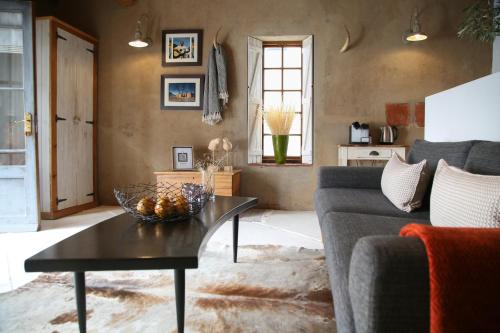 a living room with a couch and a table at Dennehof Karoo Guesthouse in Prince Albert