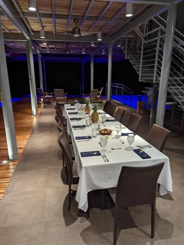 a long dining room with a long table and chairs at Cielo Lodge in Golfito