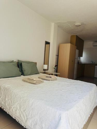 a large white bed with green pillows on it at Marielenas in Larnaca