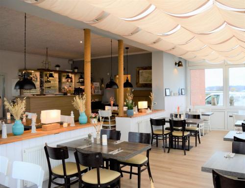 a restaurant with tables and chairs and a bar at Ostseeferienpark Walkyrien - Lotse 03 in Neustadt in Holstein