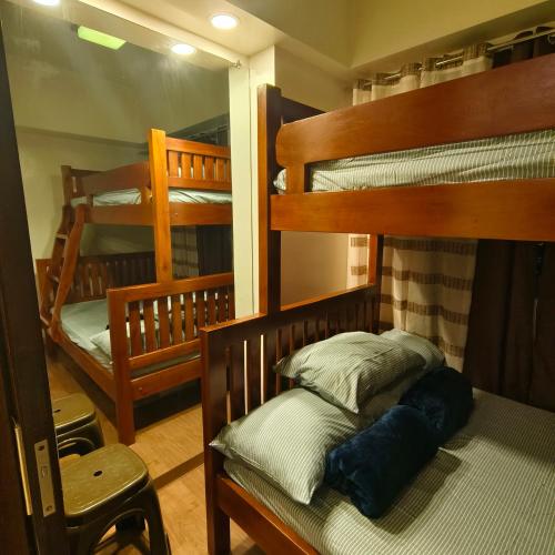 碧瑶Affordable 1BR Condo near town with WIFI - 111的有两张双层床和一把椅子的房间