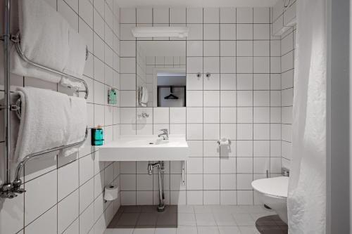 a white bathroom with a sink and a toilet at Tanumstrand SPA & Resort Stugor in Grebbestad