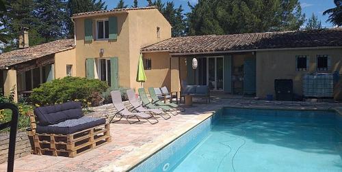 une maison avec une piscine et des chaises dans l'établissement Villa Serenité avec Piscine au Coeur du Luberon, à La Tour-dʼAigues
