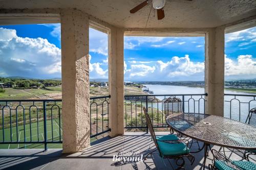 a balcony with a table and chairs and a view of the water at Sunset & Lake View on Island Retreat in Lago Vista