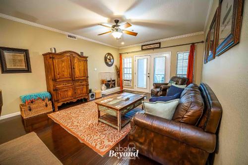 a living room with a leather couch and a table at Sunset & Lake View on Island Retreat in Lago Vista