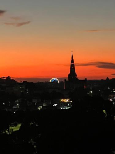 a sunset view of a city with a ferris wheel at Come live the Keike experience! in Canela