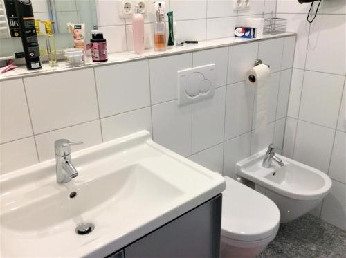 a white bathroom with a sink and a toilet at Ferienwohnung PanoramicHarz App459 in Braunlage