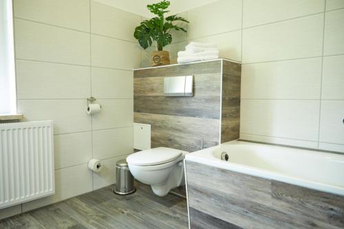 a bathroom with a toilet and a bath tub at City-Apartment 1 in Bernburg