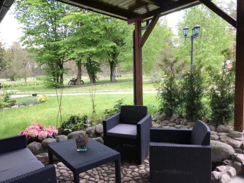 a patio with chairs and tables and a gazebo at Waldoase 2 in Rheinsberg