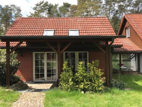 a house with a red roof at Waldoase 2 in Rheinsberg