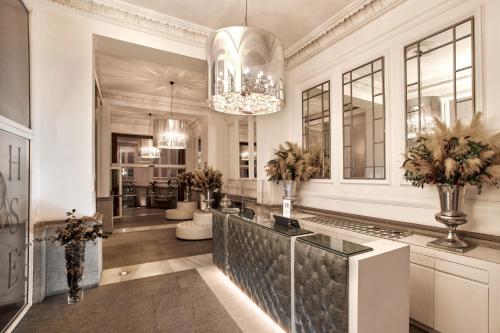 a living room with a chandelier and a lobby at Hospes Puerta de Alcalá, a Member of Design Hotels in Madrid