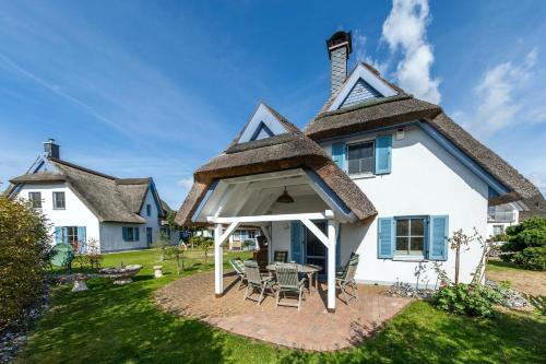ein Haus mit Strohdach und Terrasse in der Unterkunft Ferienhaus Muschelsucher in Glowe