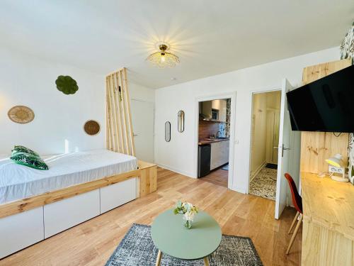 une chambre avec un grand lit et une table dans l'établissement Le Mosaïque, à Périgueux