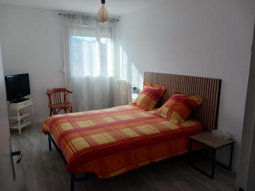 une chambre avec un lit, une télévision et une fenêtre dans l'établissement Superbe appartement avec parking privatif, à Cahors