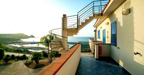 a balcony of a building with a staircase and the ocean at Magico Appartamenti Scafa - Marina Capo d'Orlando in Capo dʼOrlando