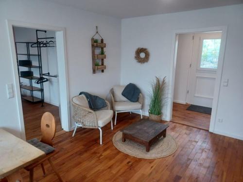a living room with two chairs and a table at Rösslerhof Ferienwohnung Obstwiese in Schlier-Unterankenreute