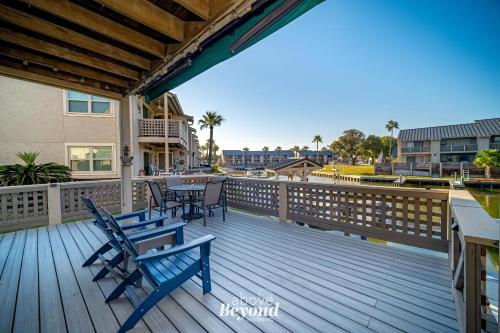 a wooden deck with chairs and tables on it at The Cobalt Crab Oasis in Rockport
