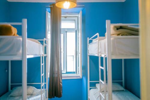 two bunk beds in a blue room with a window at Hostel Marques de Pombal in Lisbon