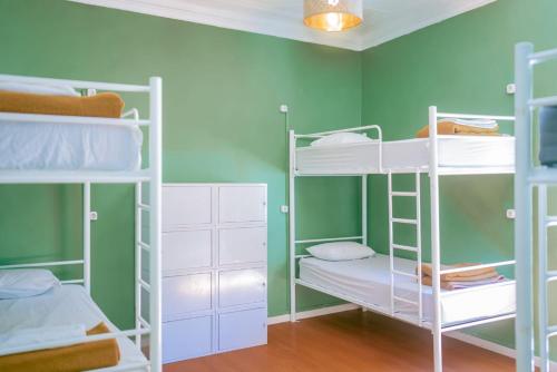 a room with bunk beds and green walls at Hostel Marques de Pombal in Lisbon