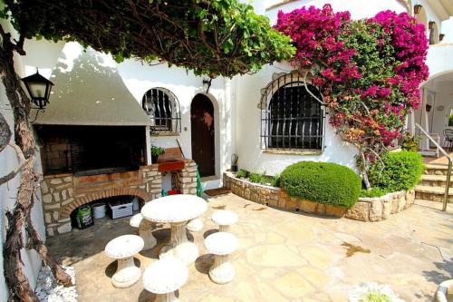 a courtyard with a table and chairs and flowers at Casa BOWA in Hospitalet de l'Infant