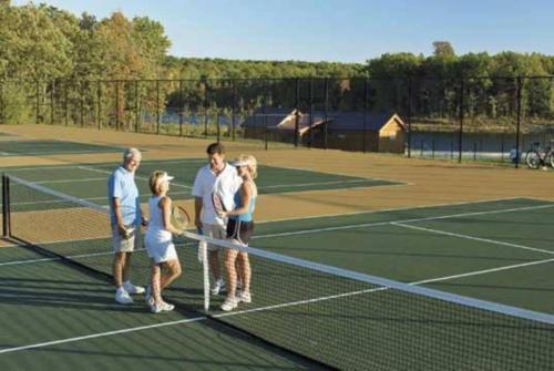 a group of people standing on a tennis court at Cliff Davidson in Sampson
