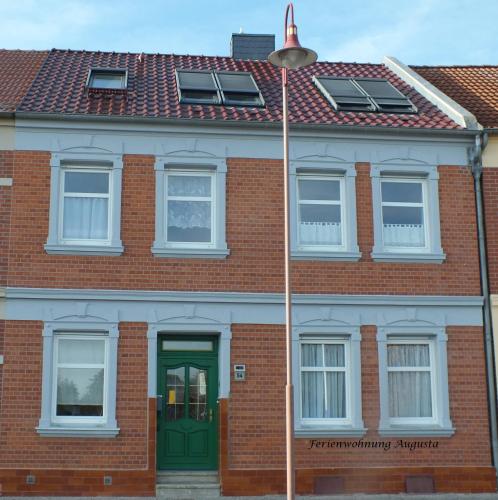 a brick house with a green door and a street light at Fewo Augusta in Tangermünde