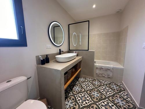 une salle de bain avec un lavabo, une baignoire et un miroir dans l'établissement Contemporary charming villa, à Sommières