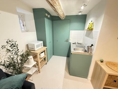 une petite cuisine avec un évier et un micro-ondes dans l'établissement NEW - Studio Vieil Antibes - Les Remparts, à Antibes
