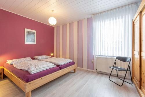 una camera da letto con un letto e una sedia di Gartenhaus a Fehmarn