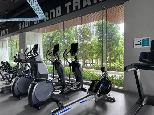 a gym with a row of cardio machines in front of a window at Sentral Suites Kuala lumpur By Leyla 3BR suites 8 pax in Kuala Lumpur