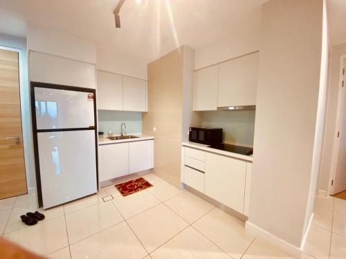 a kitchen with white cabinets and a white refrigerator at Sentral Suites Kuala lumpur By Leyla 3BR suites 8 pax in Kuala Lumpur